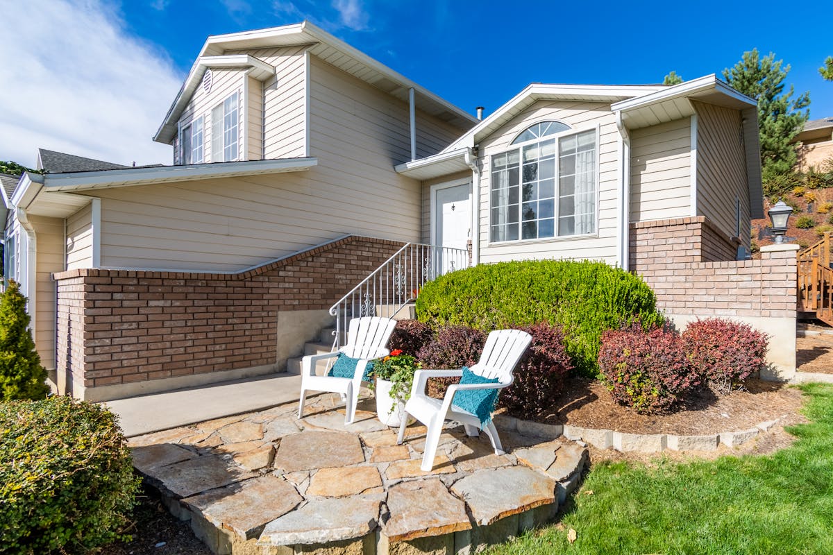 A warm suburban home exterior with stone path and mature landscaping